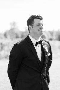 black and white image of grooms reaction to bride