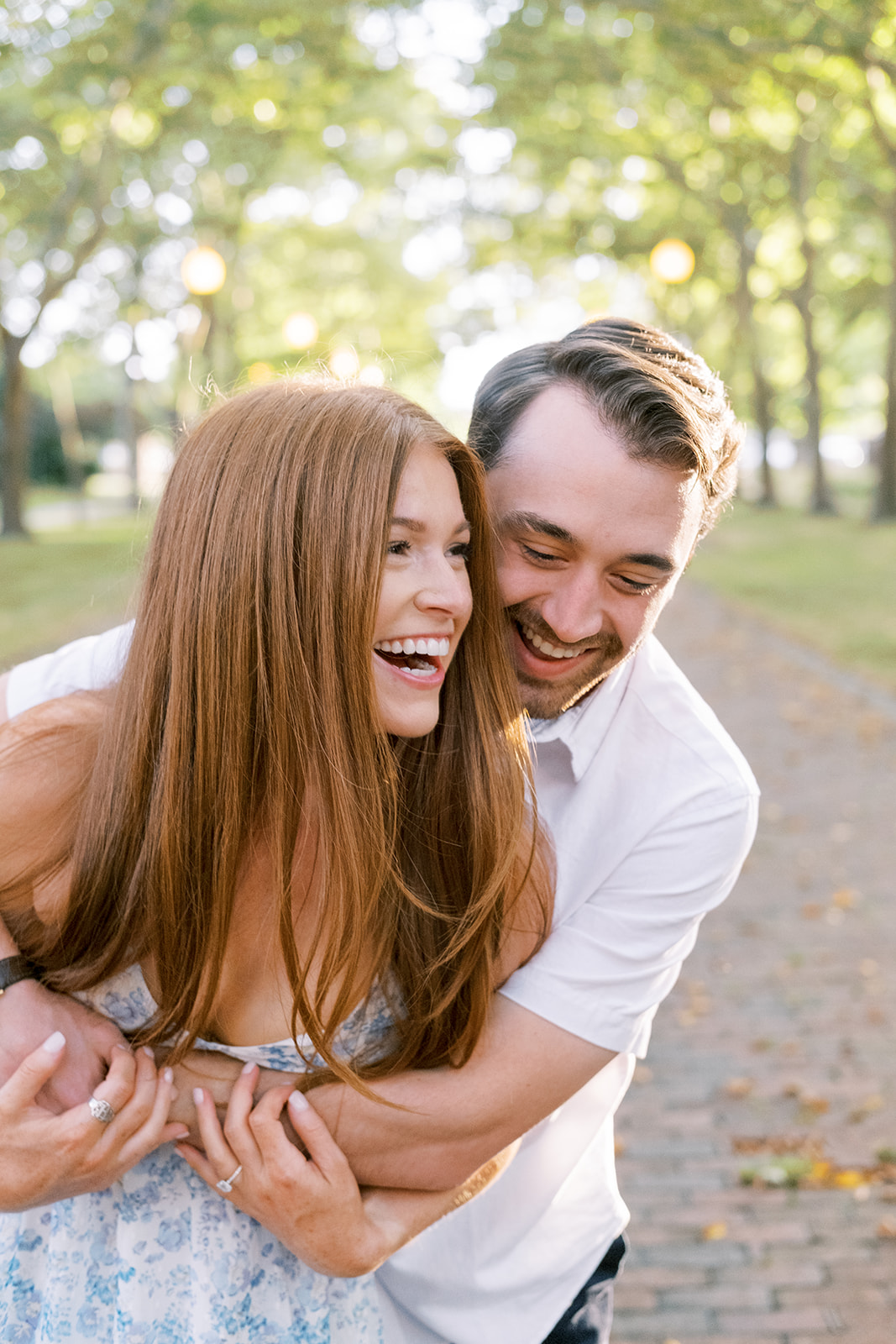 Couple laughing during their engagement session with Olivia Wenzel Photography.